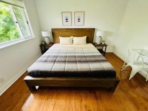 a bedroom with a bed with two tables and a window at Letitia Heights !F Spacious and Stylish Private Bedroom with Shared Bathroom in Barrie