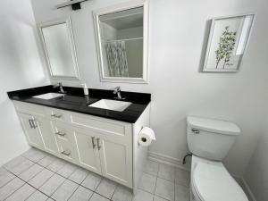 a white bathroom with a sink and a toilet at Letitia Heights !F Spacious and Stylish Private Bedroom with Shared Bathroom in Barrie