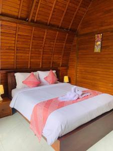 a bedroom with a large bed with red and white pillows at Volcano Valley in Kintamani