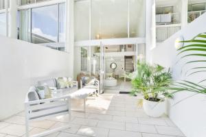 パーム・コーブにあるHotel Drift 3205 Beachfront Accomodationの白い家具と植物のあるリビングルーム