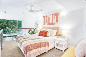 パーム・コーブにあるHotel Drift 3205 Beachfront Accomodationの白いベッドルーム(ベッド1台、バルコニー付)