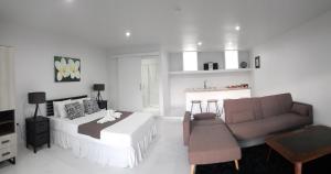Habitación blanca con cama y sofá en Kaila Na Ua Resort, en Korotogo
