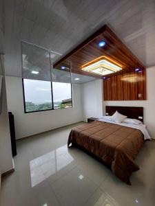 San Miguel de los BancosにあるHotel La Cascadaのベッドルーム(大型ベッド1台、大きな窓付)