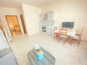 a living room with a table and a kitchen at Orlandi Sun casa 2 in Sarnano