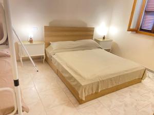 un letto in una camera da letto con due comodini e due tavoli di Orlandi Sun casa 2 a Sarnano