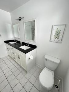 a white bathroom with a toilet and a sink at Letitia Heights !G Stylish and Spacious Private Bedroom with Shared Bathroom in Barrie