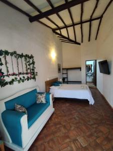 une chambre d'hôtel avec deux lits et un canapé dans l'établissement Casa Hostal Colonial VaraEchada, à Barichara
