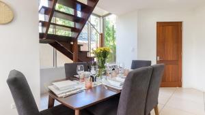 a dining room with a wooden table and chairs at Watermark Villa Port Douglas in Port Douglas