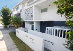 a white house with a staircase in front of it at Unit 4 - Manly Boutique Apartments in Brisbane