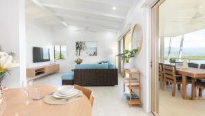 - un salon et une salle à manger avec un canapé et une table dans l'établissement Island Point Villa 6 Port Douglas, à Port Douglas