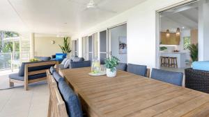 - une salle à manger et un salon avec une table et des chaises en bois dans l'établissement Island Point Villa 6 Port Douglas, à Port Douglas