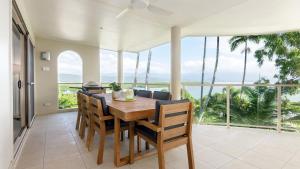 - une salle à manger avec une table et des chaises et une vue sur l'océan dans l'établissement Island Point Villa 6 Port Douglas, à Port Douglas