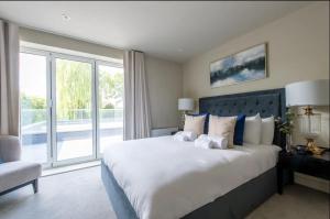 ein Schlafzimmer mit einem großen Bett und einem großen Fenster in der Unterkunft 2BD, 2BA Urban Oasis CHCL F4 in Chigwell
