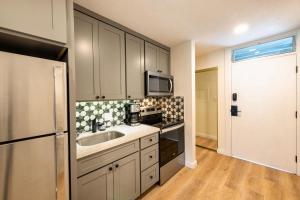 a kitchen with a sink and a microwave at Newly Renovated Studio on First Floor in Quiet Complex Across the Street from the Beach in Kihei