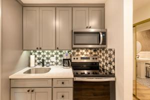 a kitchen with a sink and a microwave at Newly Renovated Studio on First Floor in Quiet Complex Across the Street from the Beach in Kihei