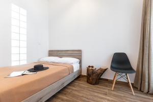 a bedroom with a bed and a black chair at Casa Estiva Naxos Apartments in Naxos Chora