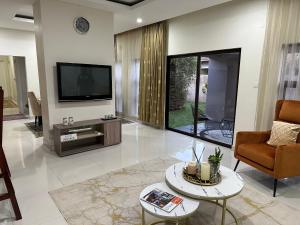 a living room with a tv and a couch and a table at Kaya Apartments in Lusaka