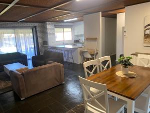 a living room and kitchen with a table and a couch at Tatura Country Motel in Tatura