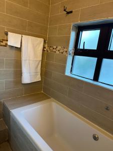 a bath tub in a bathroom with a window at Kaya Apartments in Lusaka