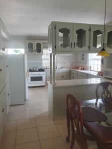 Gwa Kay的住宿－Campbell's living accommodations.，厨房配有桌子和白色冰箱。