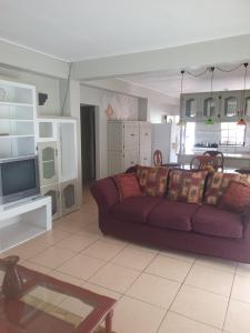 sala de estar con sofá púrpura y TV en Campbell's living accommodations., en Gwa Kay