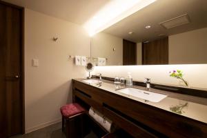 a bathroom with a sink and a large mirror at Hotel GrandBach Sendai in Sendai