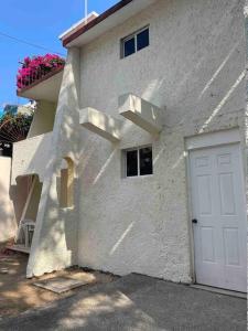 a white building with a white door and a window at Casa Caleta renta para Vacaciones a 10minplaya in Acapulco