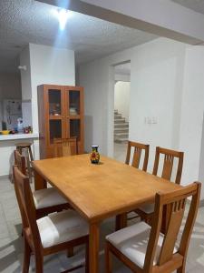 a wooden table with chairs and a vase on it at Casa Caleta renta para Vacaciones a 10minplaya in Acapulco