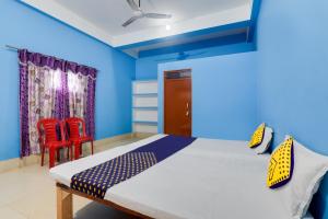 a bedroom with a bed and two red chairs at SPOT ON New Modern Guest House in Varanasi