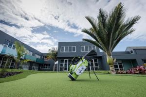 un equipo de golf en el césped frente a un edificio en Naumi Auckland Airport Hotel en Auckland