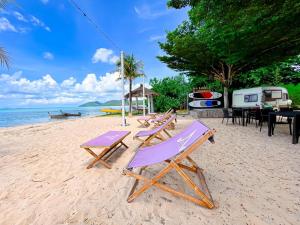 een groep stoelen en tafels op een strand bij Baan Taranya Koh Yao Yai - SHA Extra Plus in Ko Yao Yai