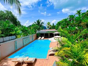 ein Bild eines Pools in einem Resort mit Liegestühlen in der Unterkunft Baan Taranya Koh Yao Yai - SHA Extra Plus in Ko Yao Yai