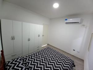 um quarto com armários brancos e um tapete preto e branco em Casa Costa Sur em Posadas
