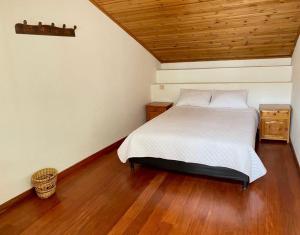 um quarto com uma cama e um tecto de madeira em Hospedaje Casa Lola em Susa