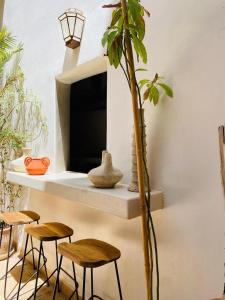 a room with three stools and a shelf with a plant at Riad Casa nomad in Marrakesh