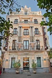 a large white building with windows and a balcony at Petit Palace Canalejas Sevilla in Seville