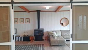 ein Wohnzimmer mit einem Sofa und einem Holzofen in der Unterkunft Captains on-the-seafront - stunning sea views- 4br 2bth - large waterfront house in Kingscote