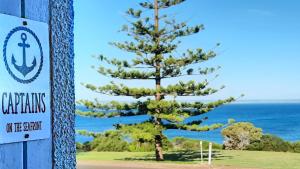 a pine tree next to a sign on the beach at Captains on-the-seafront - stunning sea views- 4br 2bth - large waterfront house in Kingscote