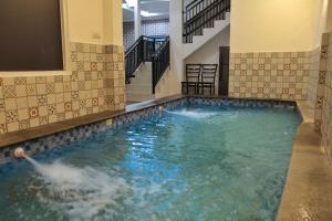 een groot zwembad met water in een gebouw met trappen bij villa view2 sayriah in Puncak