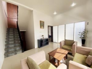 uma sala de estar com um sofá e uma mesa em villa view2 sayriah em Puncak