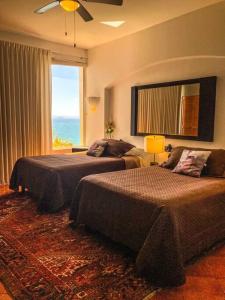 a bedroom with two beds and a large window at Condo en la playa, vista espectacular ! in La Paz