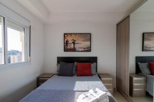a bedroom with a bed with two towels on it at Sunset Studio - GRU in Guarulhos