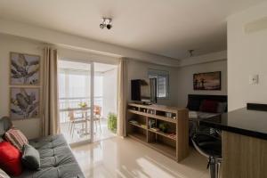 a living room with a couch and a television at Sunset Studio - GRU in Guarulhos