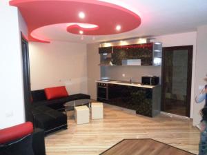 uma sala de estar com um tecto vermelho em "При братята" - Apartments & Studios em Sandanski