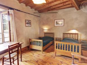 1 Schlafzimmer mit 2 Betten, einem Schreibtisch und einem Tisch in der Unterkunft Gîte Saint-Germain-Laval (Loire), 5 pièces, 8 personnes - FR-1-496-26 in Saint-Germain-Laval