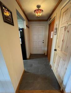 un pasillo de una casa con una puerta y una lámpara de araña en SPECIAL RATE Golfer's Paradise & 10 Minutes to Rocky Top Sports, en Gatlinburg