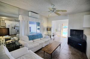 sala de estar con sofá blanco y TV en Gulfside Resort Unit 4, en St Pete Beach