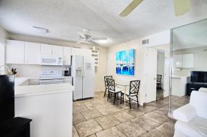 a kitchen with white cabinets and a table and chairs at Gulfside Resort Unit 4 in St. Pete Beach