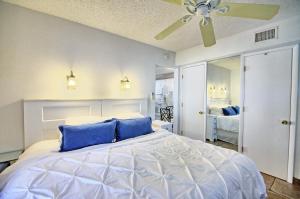 a bedroom with a large bed with blue pillows at Gulfside Resort Unit 4 in St. Pete Beach
