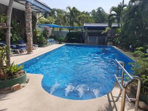 ein großer blauer Pool im Hof in der Unterkunft Villa Germania in Jomtien Beach